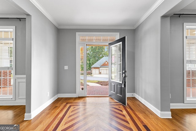 entryway with light parquet flooring, crown molding, and a healthy amount of sunlight