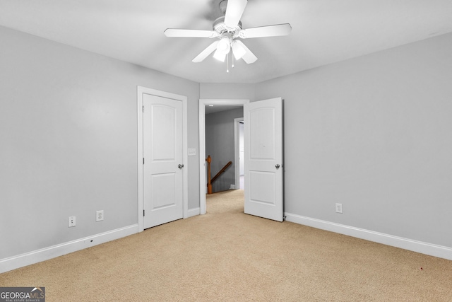 unfurnished bedroom with ceiling fan and light colored carpet