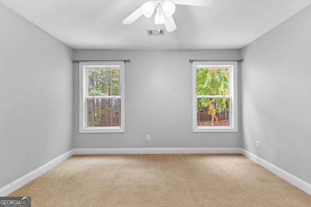 empty room featuring ceiling fan, a healthy amount of sunlight, and carpet floors