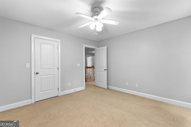 unfurnished bedroom featuring ceiling fan and light colored carpet