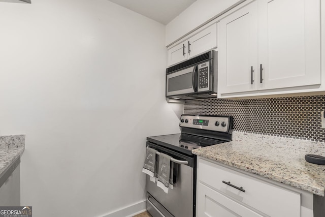 kitchen featuring electric stove, decorative backsplash, and white cabinets