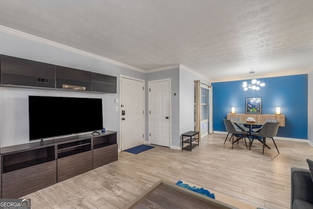 living room with a textured ceiling, light hardwood / wood-style floors, crown molding, and a notable chandelier