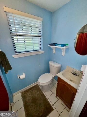 bathroom featuring vanity, tile patterned floors, and toilet