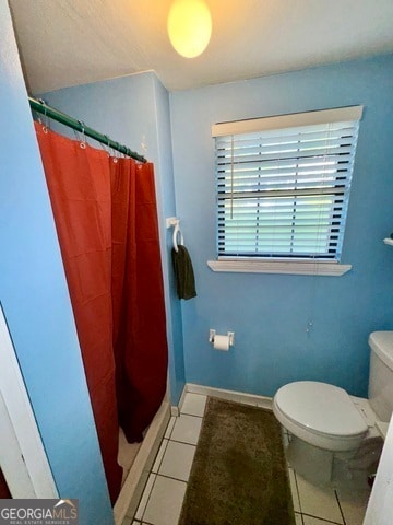 bathroom with toilet, a shower with curtain, and tile patterned floors