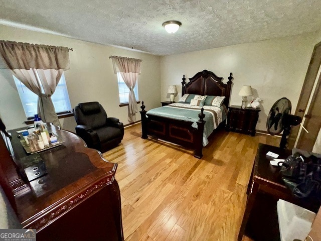 bedroom with wood-type flooring and a textured ceiling