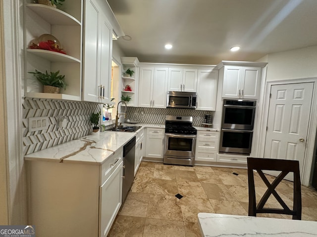 kitchen with open shelves, backsplash, appliances with stainless steel finishes, white cabinets, and a sink