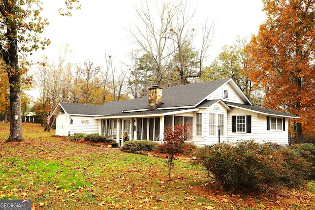 rear view of house featuring a sunroom