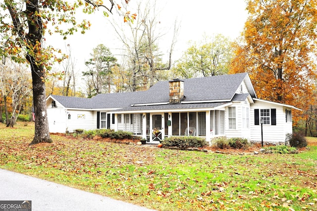 ranch-style home with a sunroom and a front lawn