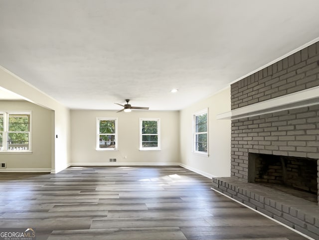 unfurnished living room with a fireplace, hardwood / wood-style flooring, crown molding, and ceiling fan