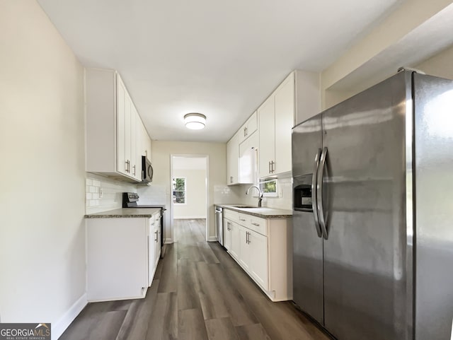 kitchen featuring white cabinets, stainless steel appliances, dark hardwood / wood-style floors, and tasteful backsplash