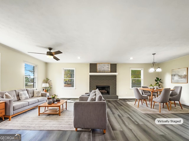 living room featuring a brick fireplace, plenty of natural light, ceiling fan, and dark hardwood / wood-style flooring