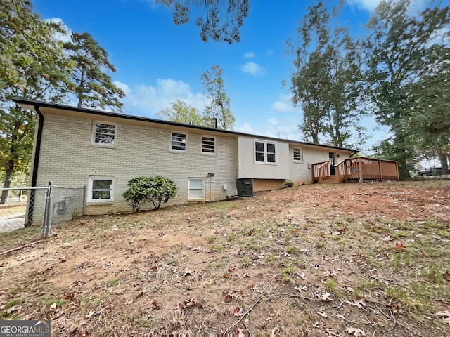 rear view of property featuring central air condition unit and a wooden deck