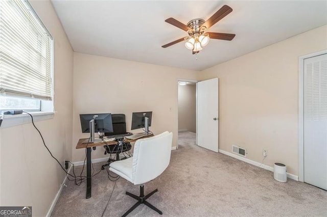 carpeted office space with ceiling fan