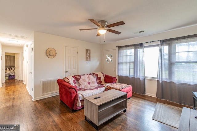 living room featuring ceiling fan and dark hardwood / wood-style flooring