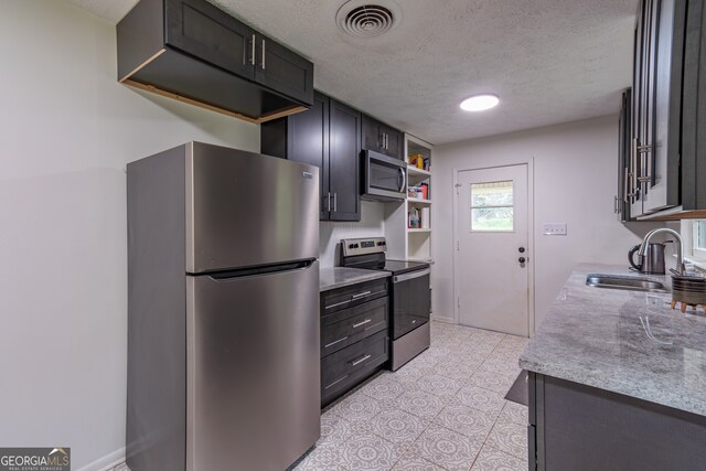 kitchen featuring appliances with stainless steel finishes, sink, and a textured ceiling