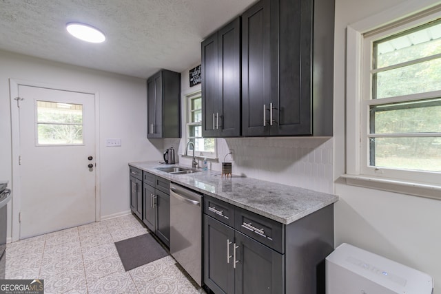 kitchen featuring stainless steel appliances, a wealth of natural light, a textured ceiling, and sink