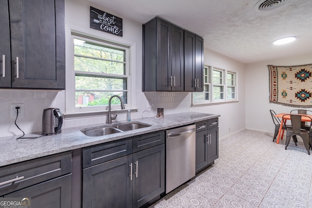 kitchen featuring a healthy amount of sunlight, decorative backsplash, stainless steel dishwasher, and sink