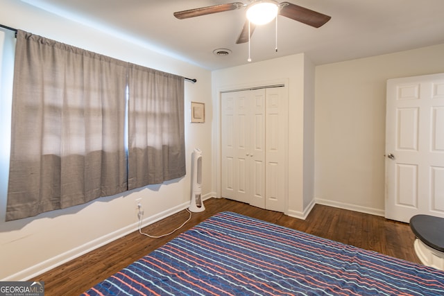 unfurnished bedroom featuring dark hardwood / wood-style flooring, ceiling fan, and a closet