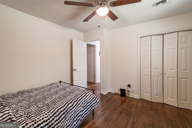 bedroom with dark hardwood / wood-style flooring, ceiling fan, and a closet