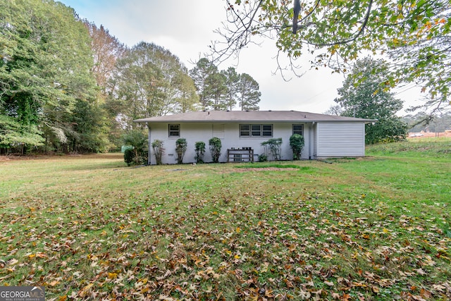 rear view of property featuring a lawn