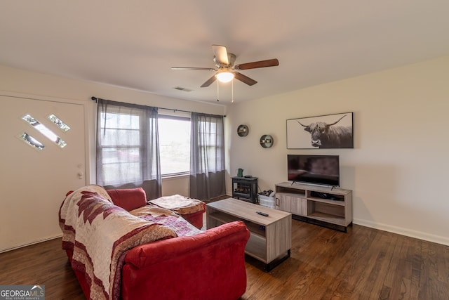 living room with dark wood-type flooring and ceiling fan