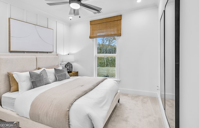 bedroom featuring ornamental molding, light colored carpet, and ceiling fan