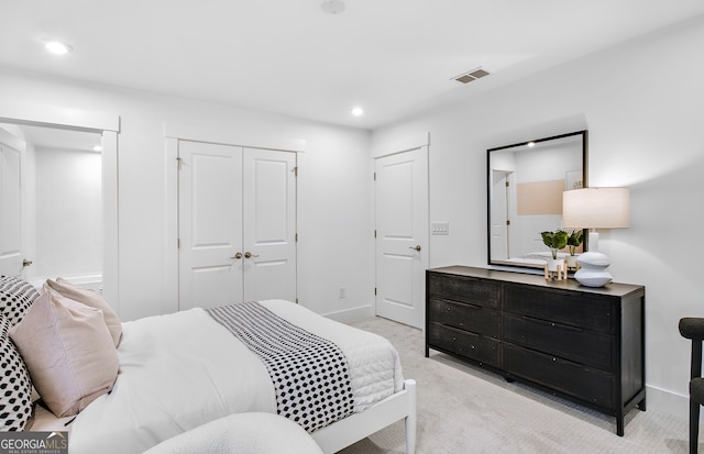 bedroom featuring light colored carpet and a closet