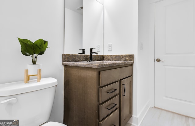 bathroom featuring toilet and vanity