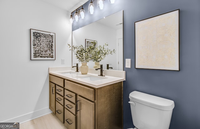 bathroom featuring wood-type flooring, toilet, and vanity