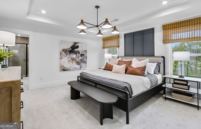 bedroom featuring light carpet, a raised ceiling, and an inviting chandelier