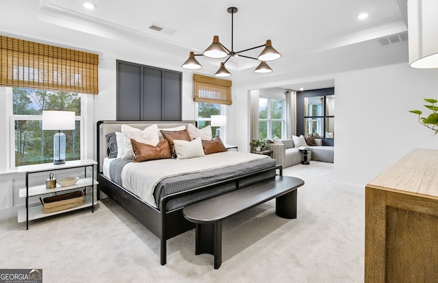 bedroom with an inviting chandelier, light colored carpet, and a raised ceiling