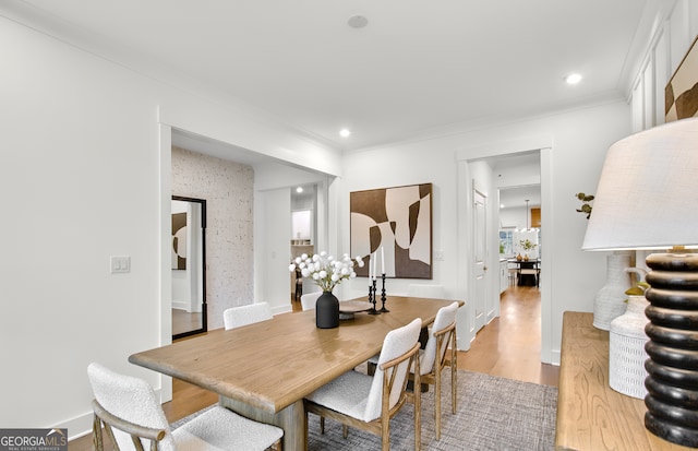 dining space with hardwood / wood-style floors and crown molding