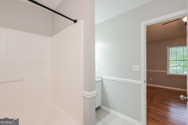 bathroom featuring wood-type flooring, vanity, a textured ceiling, and  shower combination