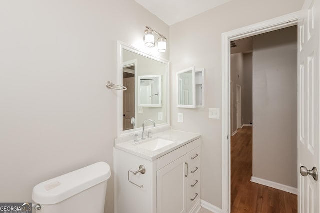 bathroom featuring toilet, vanity, and hardwood / wood-style flooring