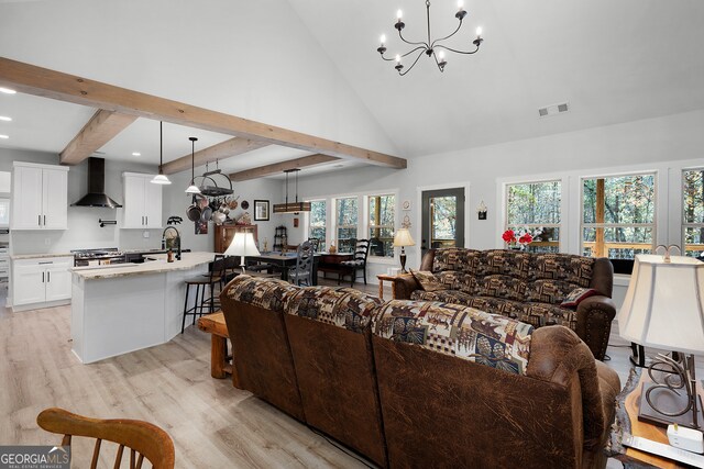 living room featuring beam ceiling, a chandelier, high vaulted ceiling, and light hardwood / wood-style floors