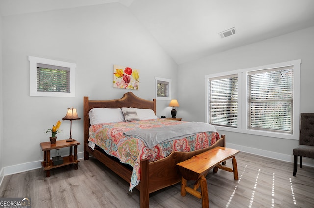 bedroom with light hardwood / wood-style floors and high vaulted ceiling