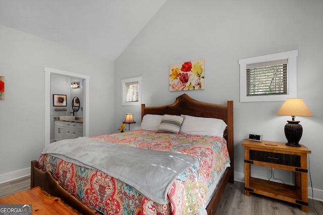 bedroom featuring wood-type flooring, connected bathroom, and high vaulted ceiling