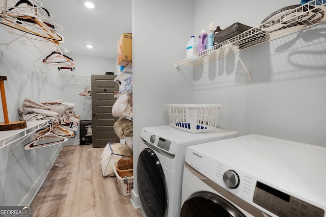 clothes washing area featuring washer and dryer and light wood-type flooring