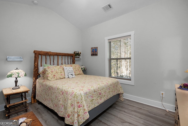 bedroom with wood-type flooring and lofted ceiling