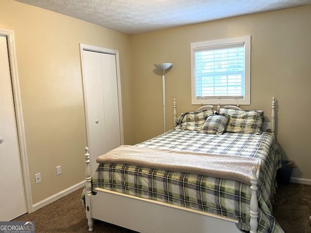 bedroom with dark colored carpet, a closet, and a textured ceiling