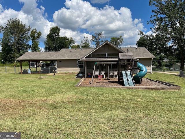 rear view of property featuring a playground and a lawn