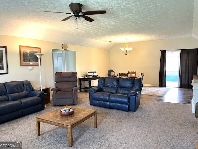 carpeted living room featuring ceiling fan with notable chandelier, a textured ceiling, and vaulted ceiling