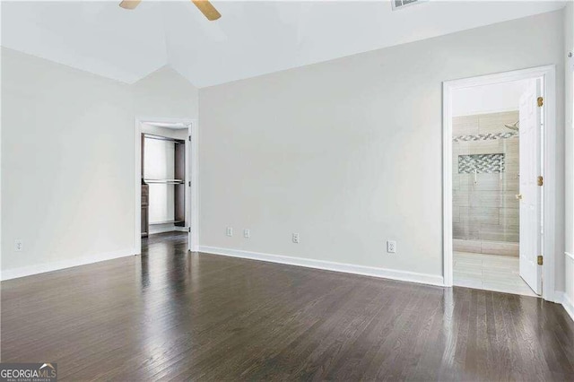 unfurnished bedroom with vaulted ceiling, dark hardwood / wood-style floors, ensuite bath, and ceiling fan