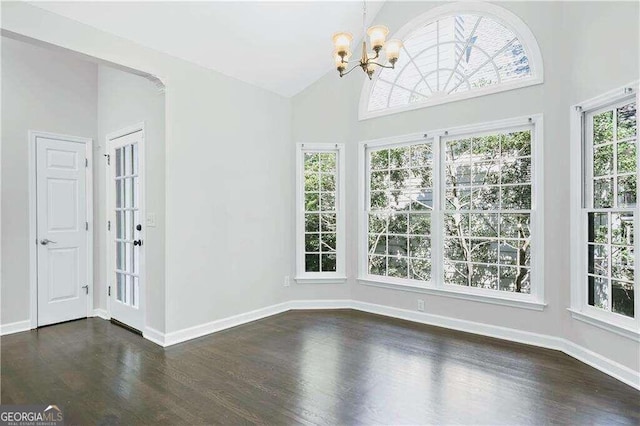 interior space featuring dark wood-type flooring, high vaulted ceiling, and a notable chandelier