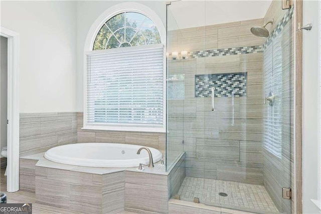 bathroom with toilet and plus walk in shower