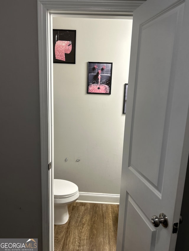 bathroom featuring wood-type flooring and toilet