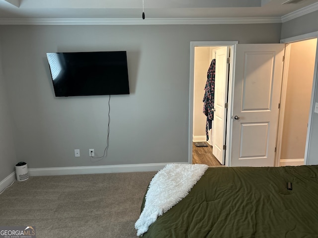 bedroom with ornamental molding and light carpet