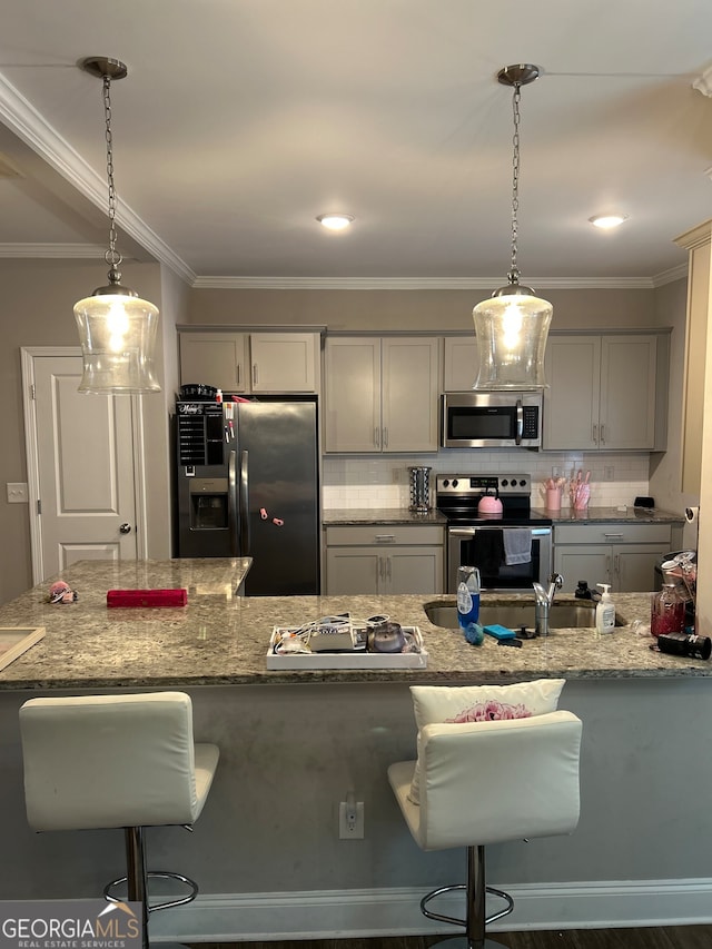 kitchen featuring hanging light fixtures, a breakfast bar area, and stainless steel appliances