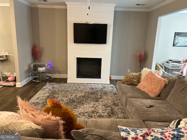 living room featuring a large fireplace, dark wood-type flooring, and crown molding