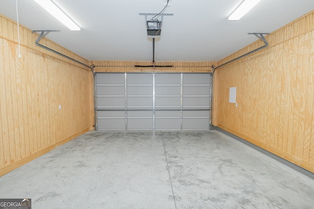 garage featuring a garage door opener and wooden walls